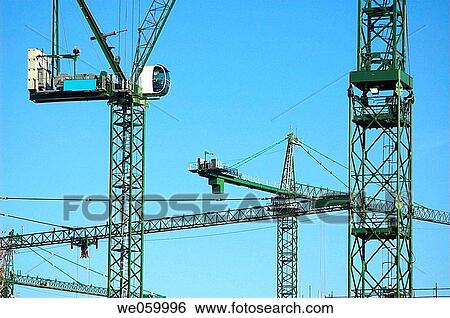 Construction cranes on site at large scale urban regeneration project. View Large Photo Image Stock Photograph - Construction cranes on site at large scale urban regeneration project.. Fotosearch