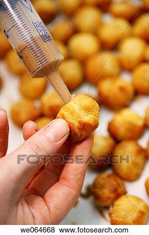 Filling out fritters with chocolate View Large Photo Image Stock Photo - Filling out fritters with chocolate. Fotosearch