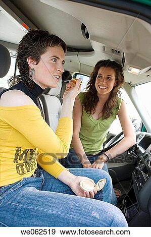 Friends applying make-up in a camper van. View Large Photo Image Stock Photo - Friends applying make-up in a camper van.. Fotosearch