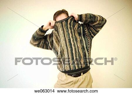 Man pulling his sweater up over his head View Large Photo Image Picture - Man pulling his sweater up over his head. Fotosearch