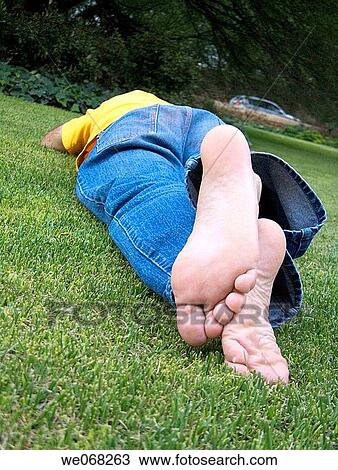 Stock Image - Man sleeping in a garden. Fotosearch