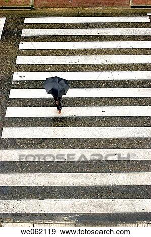 Man with umbrella crossing the street View Large Photo Image Stock Photo - Man with umbrella crossing the street. Fotosearch