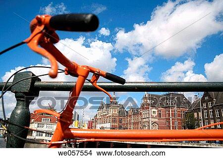 Picture - Orange bike parking at central station in Amsterdam, Holland, Netherlands. Fotosearch