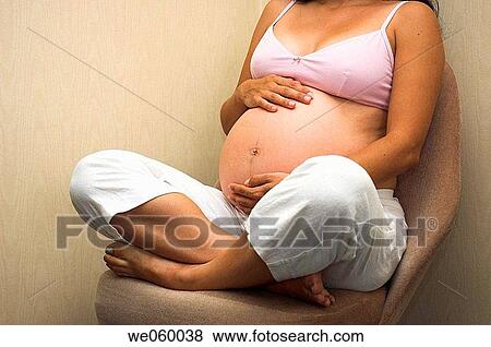Pregnant woman holding her bump and enjoying the experience of pregnancy. View Large Photo Image Stock Photo - Pregnant woman holding her bump and enjoying the experience of pregnancy.. Fotosearch