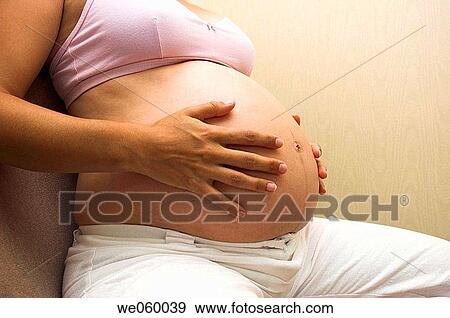 Pregnant woman holding her bump and enjoying the experience of pregnancy. View Large Photo Image Stock Photo - Pregnant woman holding her bump and enjoying the experience of pregnancy.. Fotosearch