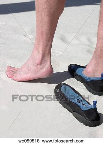 Stock Photo - Stepping out of shoe to test the sand. Fotosearch