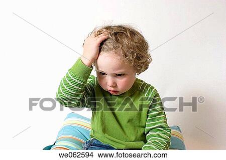 Three-year-old boy holding his head View Large Photo Image Picture - Three-year-old boy holding his head. Fotosearch