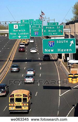 Stock Photography - Traffic signs and automobiles on a stretch of highway going through a city.. Fotosearch