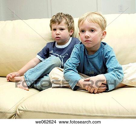Two four-year-old boys watching television. View Large Photo Image Picture - Two four-year-old boys watching television.. Fotosearch