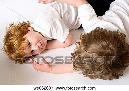 Stock Photo - Two three-year-old boys lying down and talking.. Fotosearch