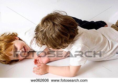 Stock Photograph - Two three-year-old boys lying down and talking.. Fotosearch