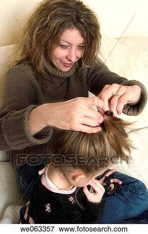 Woman fixing her young daughter's hair. View Large Photo Image Stock Photo - Woman fixing her young daughter's hair.. Fotosearch