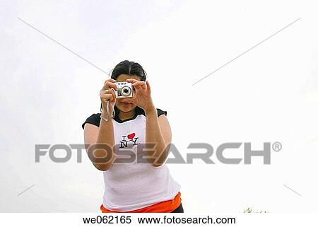 Woman holding a digital camera. T-shirt reads? I love New York?. View Large Photo Image Stock Photography - Woman holding a digital camera. T-shirt reads? I love New York?.. Fotosearch