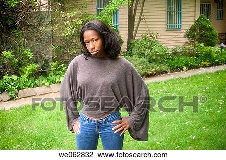 Young black woman posing in front of her house View Large Photo Image Stock Image - Young black woman posing in front of her house. Fotosearch