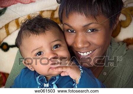 Stock Image - Young black woman posing with her toddler niece. Fotosearch