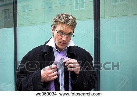 Young businessman fixing his neck tie. View Large Photo Image Picture - Young businessman fixing his neck tie.. Fotosearch