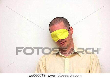 Young businessman gabbing a quick cat nap wearing an eye mask. View Large Photo Image Stock Photo - Young businessman gabbing a quick cat nap wearing an eye mask.. Fotosearch