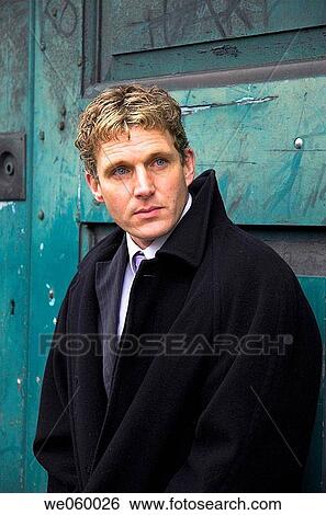 Young businessman leaning against old industrial door. View Large Photo Image Stock Photograph - Young businessman leaning against old industrial door.. Fotosearch