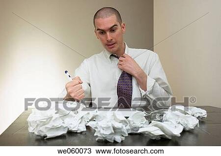 Young businessman struggling with some paperwork and expressing frustration in his body language. View Large Photo Image Stock Image - Young businessman struggling with some paperwork and expressing frustration in his body language.. Fotosearch