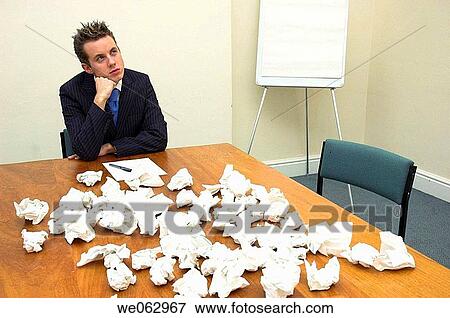 Stock Photo - Young businessman struggling with paperwork.. Fotosearch