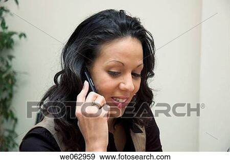 Young businesswoman using her mobile phone during a meeting. View Large Photo Image Stock Photo - Young businesswoman using her mobile phone during a meeting.. Fotosearch
