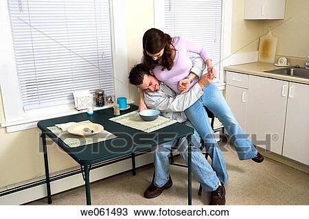 Young couple playing together in their kitchen View Large Photo Image Stock Image - Young couple playing together in their kitchen. Fotosearch
