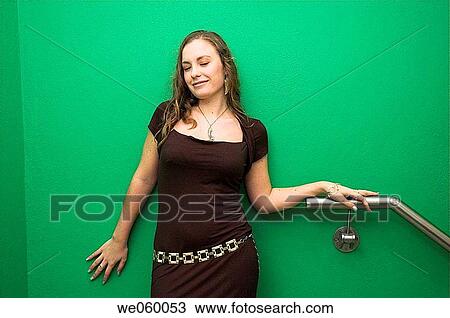 Young female fashion model posing against a green wall. View Large Photo Image Stock Image - Young female fashion model posing against a green wall.. Fotosearch