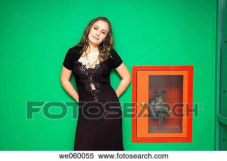 Young female fashion model posing against a green wall and fire hydrant. View Large Photo Image Stock Photography - Young female fashion model posing against a green wall and fire hydrant.. Fotosearch