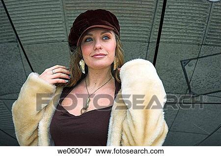 Stock Photo - Young female fashion model wearing a fur coat.. Fotosearch