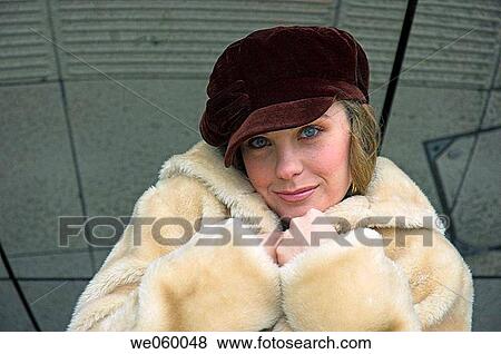 Stock Photo - Young female fashion model wearing a fur coat.. Fotosearch