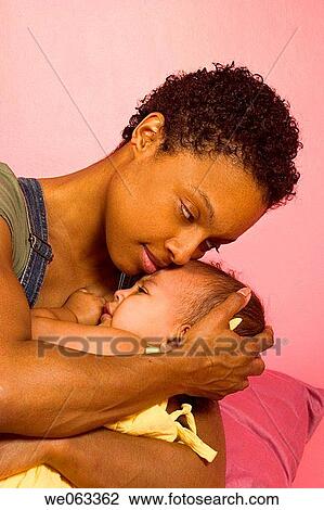 Stock Image - Young Hispanic mother holding her Hispanic/Italian toddler daughter.. Fotosearch