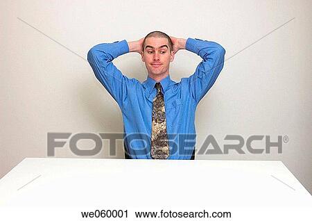 Young man in business shirt and tie sitting at an empty desk. Body language suggests a lack of work to do. View Large Photo Image Stock Image - Young man in business shirt and tie sitting at an empty desk. Body language suggests a lack of work to do.. Fotosearch