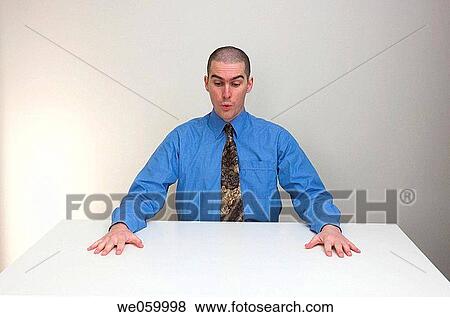 Young man in business shirt and tie sitting at an empty desk. Expression suggests relief, or bewilderment, at having a clear desk. View Large Photo Image Stock Photo - Young man in business shirt and tie sitting at an empty desk. Expression suggests relief, or bewilderment, at having a clear desk.. Fotosearch