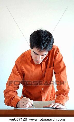 Stock Image - Young man signing a document.. Fotosearch