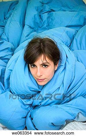 Young woman, on her bed, wrapped in a blanket. View Large Photo Image Picture - Young woman, on her bed, wrapped in a blanket.. Fotosearch