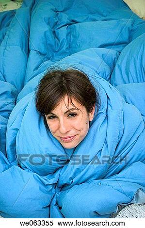 Young woman, on her bed, wrapped in a blanket. View Large Photo Image Stock Photography - Young woman, on her bed, wrapped in a blanket.. Fotosearch
