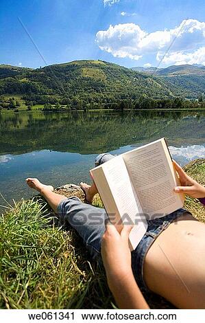 Young woman reading by lake with Pyrenees Mountains in background View Large Photo Image Stock Image - Young woman reading by lake with Pyrenees Mountains in background. Fotosearch