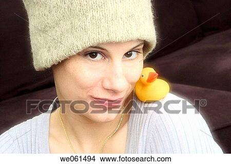 Young woman, wearing a hat, with a yellow rubber duck resting on her shoulder View Large Photo Image Picture - Young woman, wearing a hat, with a yellow rubber duck resting on her shoulder. Fotosearch
