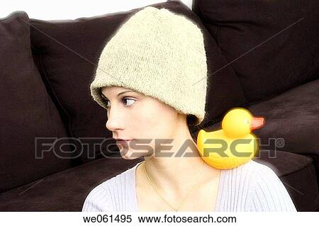 Young woman, wearing a hat, with a yellow rubber duck resting on her shoulder View Large Photo Image Stock Photography - Young woman, wearing a hat, with a yellow rubber duck resting on her shoulder. Fotosearch
