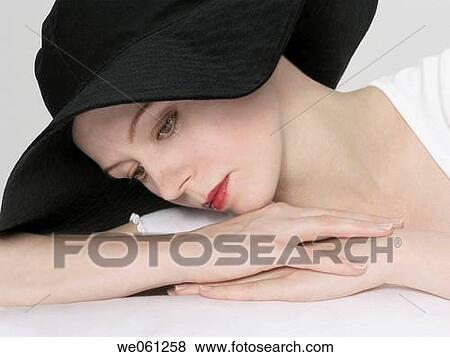 Young woman with a black hat View Large Photo Image Stock Photo - Young woman with a black hat. Fotosearch