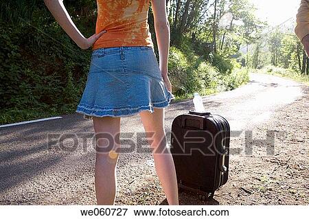 Young woman with luggage on the road View Large Photo Image Stock Photo - Young woman with luggage on the road. Fotosearch
