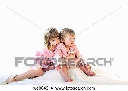 1 and 3 year old sisters sitting on the studio floor, hugging View Large Photo Image Picture - 1 and 3 year old sisters sitting on the studio floor, hugging. Fotosearch