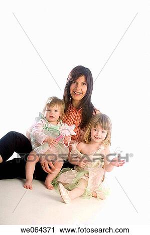 1 and 3 year old sisters sitting on the studio floor, with their mother holding them View Large Photo Image Stock Image - 1 and 3 year old sisters sitting on the studio floor, with their mother holding them. Fotosearch