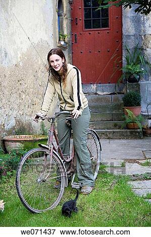 Stock Photo - 25-30 year old woman with bike. Fotosearch