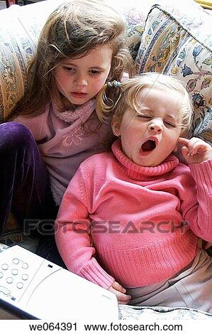 3 and a 5 year old girls sitting on the sofa watching a dvd player, the 3 year old girl is yawning View Large Photo Image Stock Image - 3 and a 5 year old girls sitting on the sofa watching a dvd player, the 3 year old girl is yawning. Fotosearch