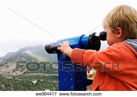 3 year old boy looking through a telescope, at the view View Large Photo Image Stock Photo - 3 year old boy looking through a telescope, at the view. Fotosearch
