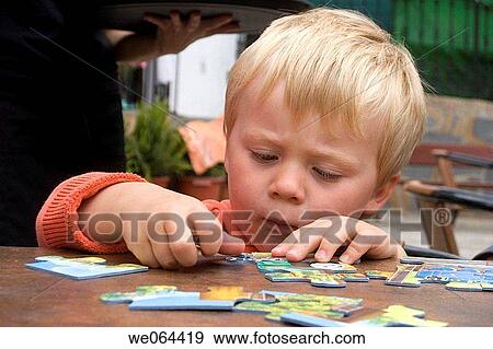 3 year old boy sitting really concentrating on a jigsaw View Large Photo Image Stock Photo - 3 year old boy sitting really concentrating on a jigsaw. Fotosearch