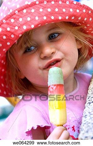 3 year old girl eating a lolly, wearing a big sunhat View Large Photo Image Stock Photo - 3 year old girl eating a lolly, wearing a big sunhat. Fotosearch
