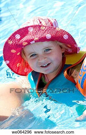 3 year old girl, on holiday in the pool, wearing a big sunhat View Large Photo Image Stock Photograph - 3 year old girl, on holiday in the pool, wearing a big sunhat. Fotosearch