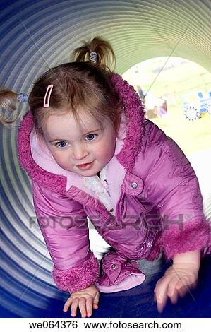 3 year old girl outside in the park, crawling through a play tunnel View Large Photo Image Stock Photograph - 3 year old girl outside in the park, crawling through a play tunnel. Fotosearch